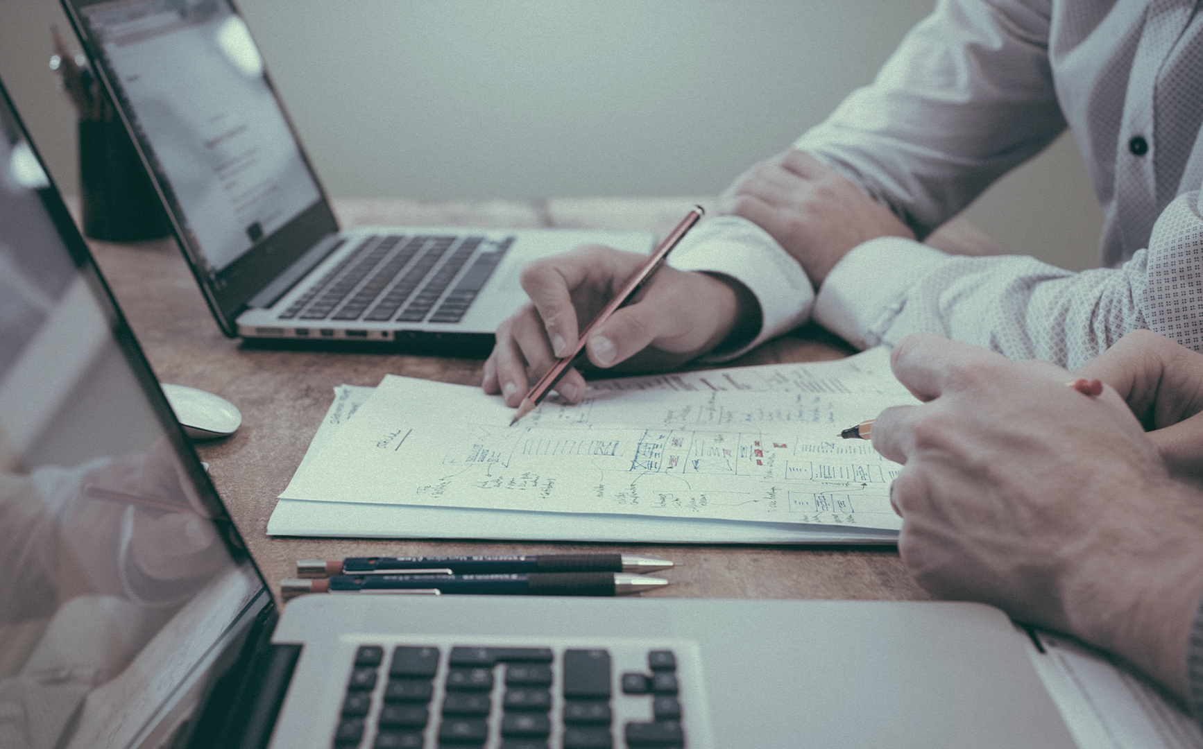 Schreibtisch mit Notizzettel und Notebooks.