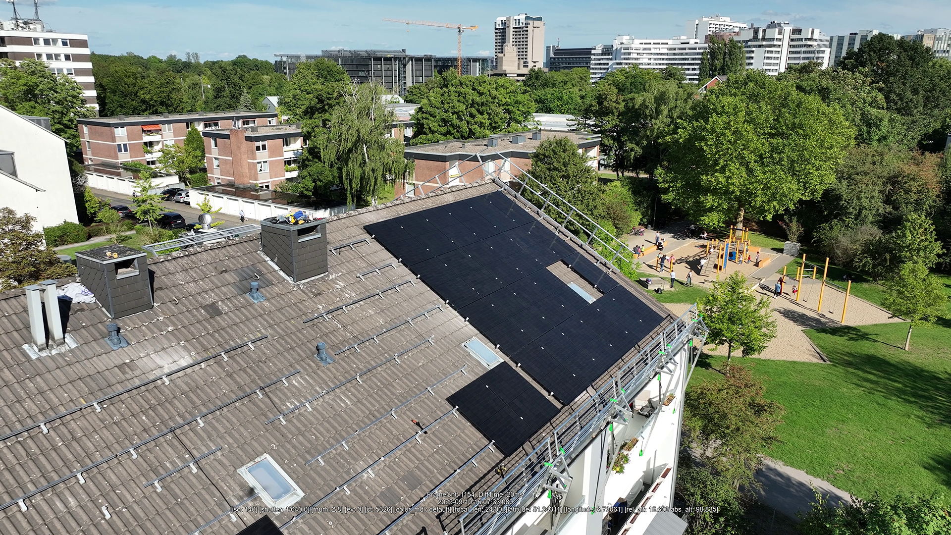 Bild zeigt Mehrfamilienhaus mit Schrägdach und neu installierter PV-Anlage.
