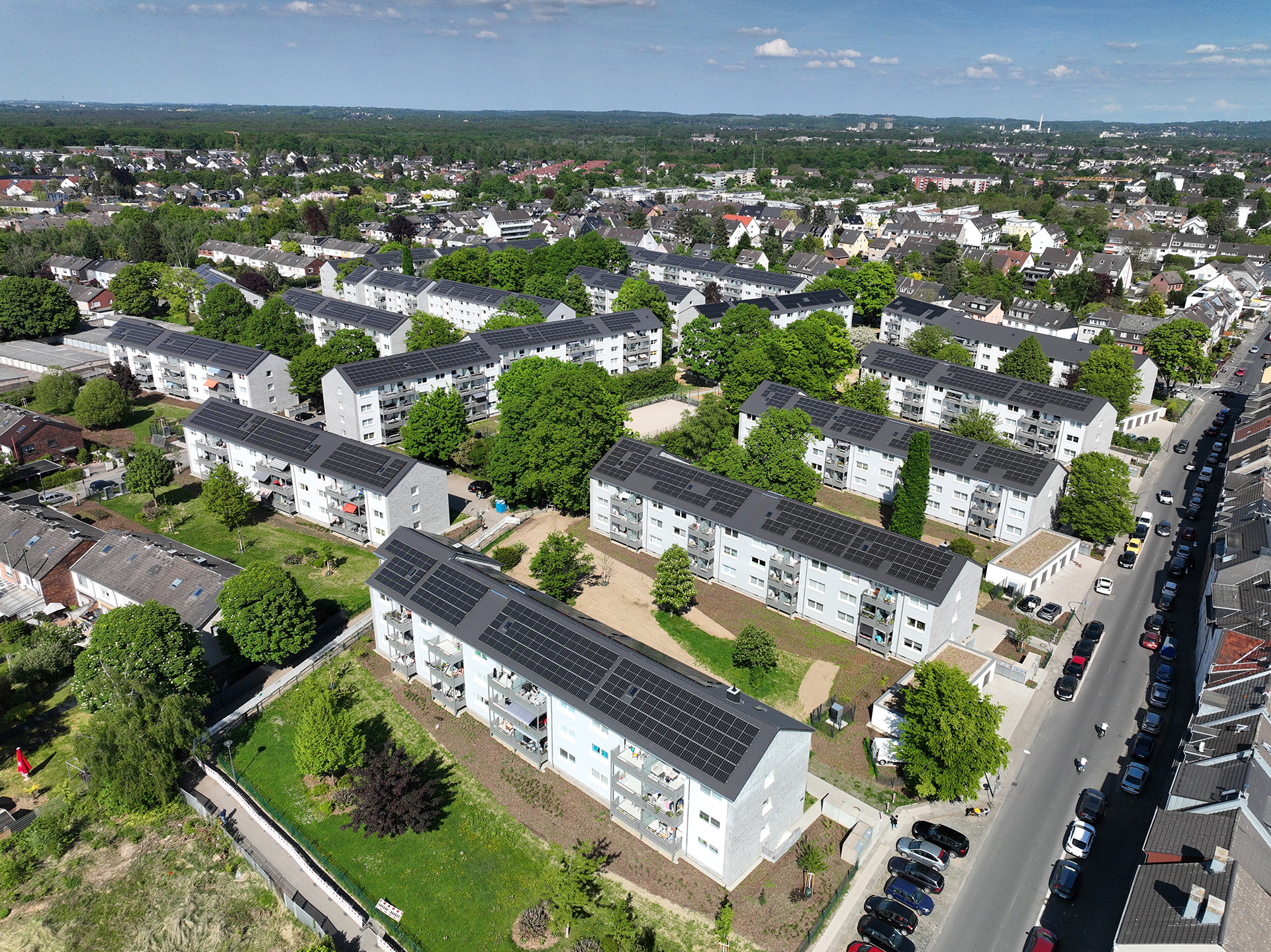 Eine Siedlung Mehrfamilienhäuser mit PV-Anlagen auf den Dächern.